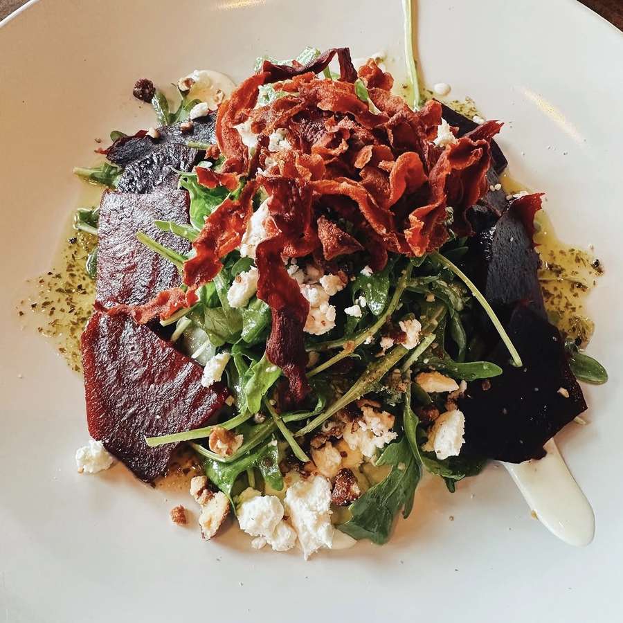 Beet salad with arugula, goat cheese, candied nuts and beet chips