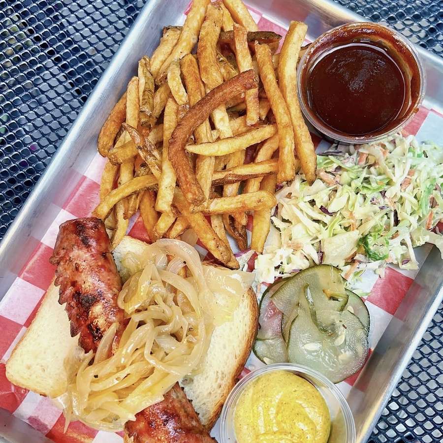 Grilled sausage tray with onions, toast, coleslaw, pickles and mustard
