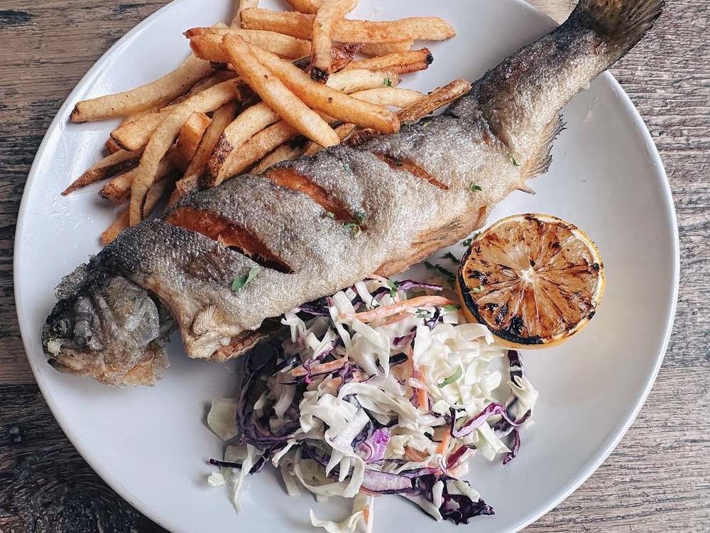 Whole trout with grilled lemon, coleslaw and fries at Spoko Chicago