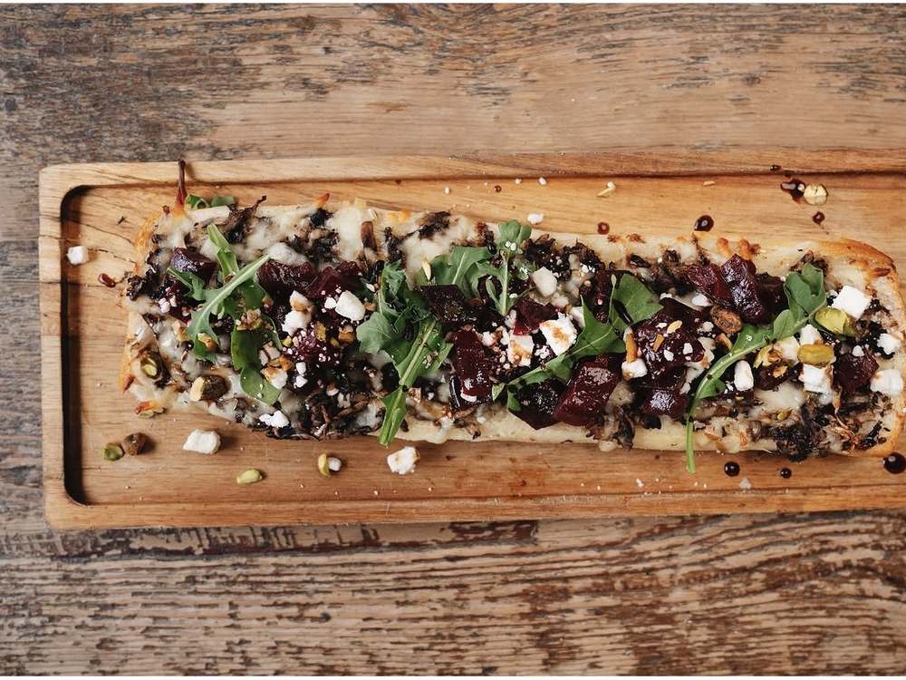 Beet and goat cheese zapiekanka with pistachios and arugula
